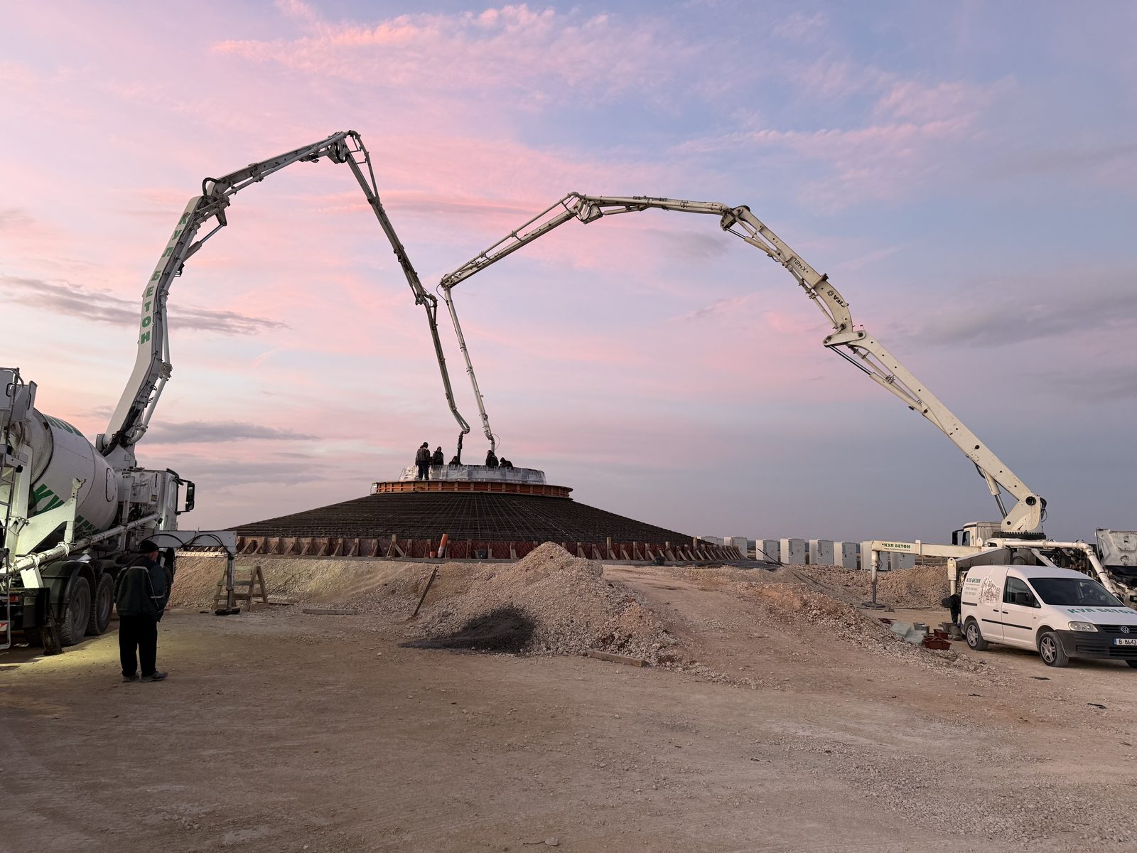Two concrete pumps pouring the Balchik Wind IV foundation under a pink evening sky