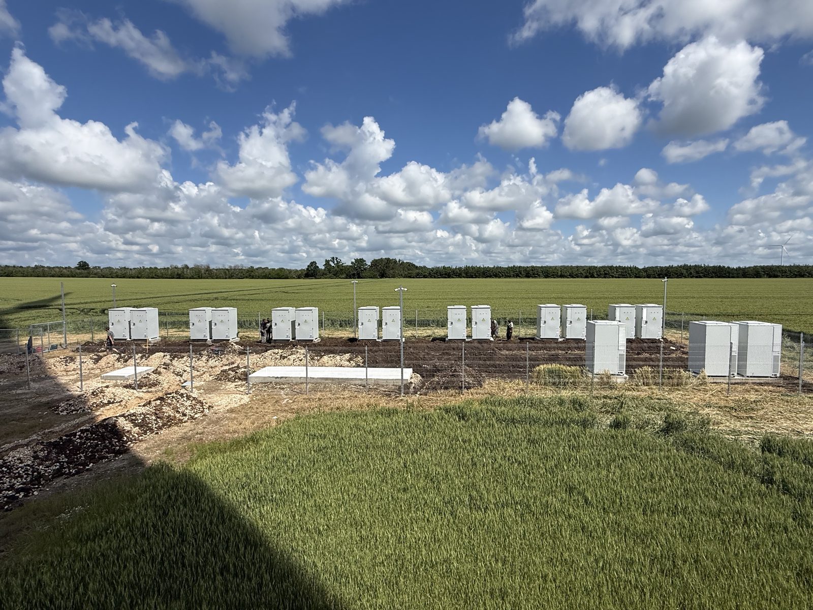 Fenced battery storage compound beside a wheat field at one of our wind sites near Balchik