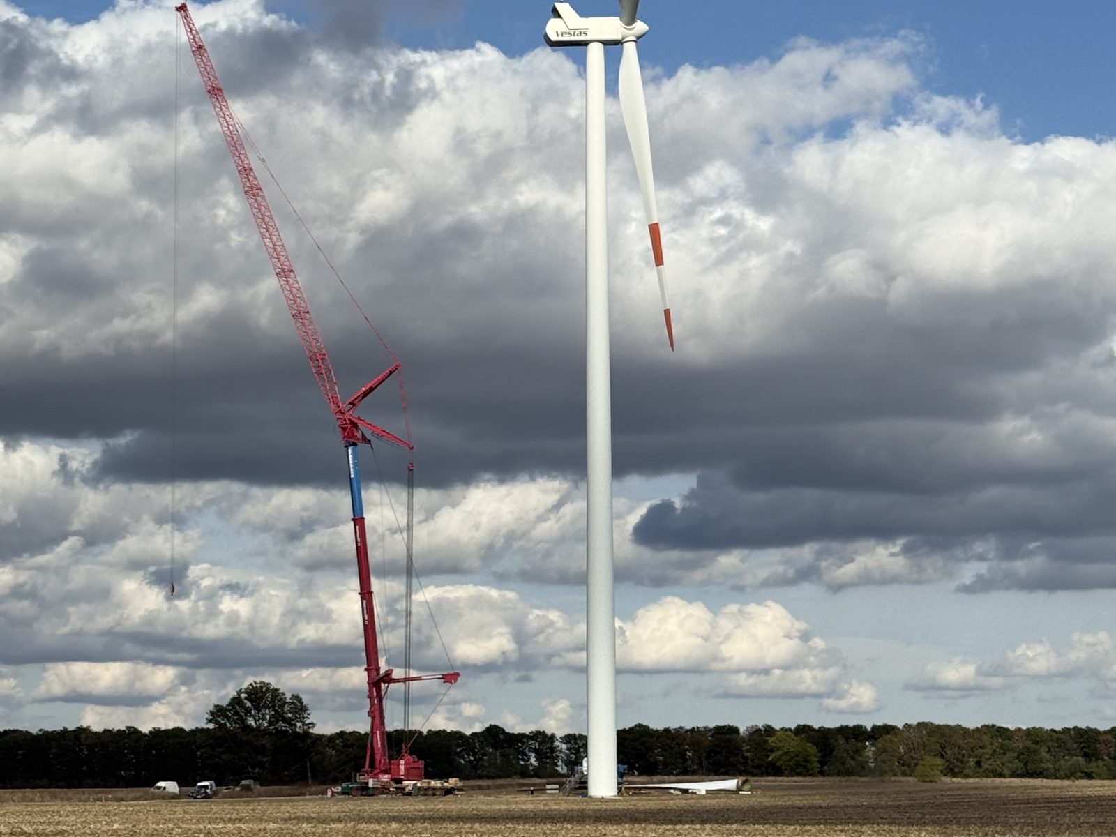 Red lattice crane beside a Ventus wind turbine near Balchik during a major component exchange