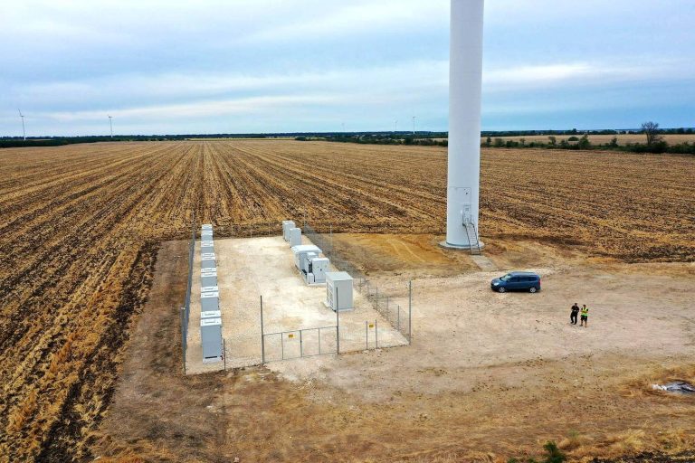 Drone view of a Balchik wind turbine with its new fenced battery storage compound